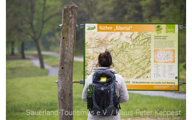 Wanderin vor einer Orientierungstafel