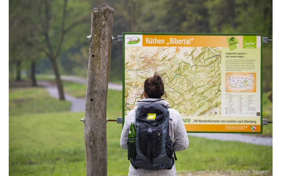 Wanderin vor einer Orientierungstafel